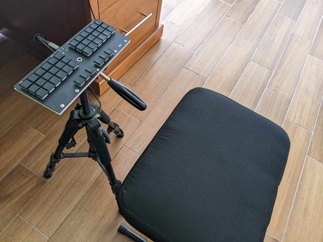Piano chair and a multisteno keyboard on a camera tripod.